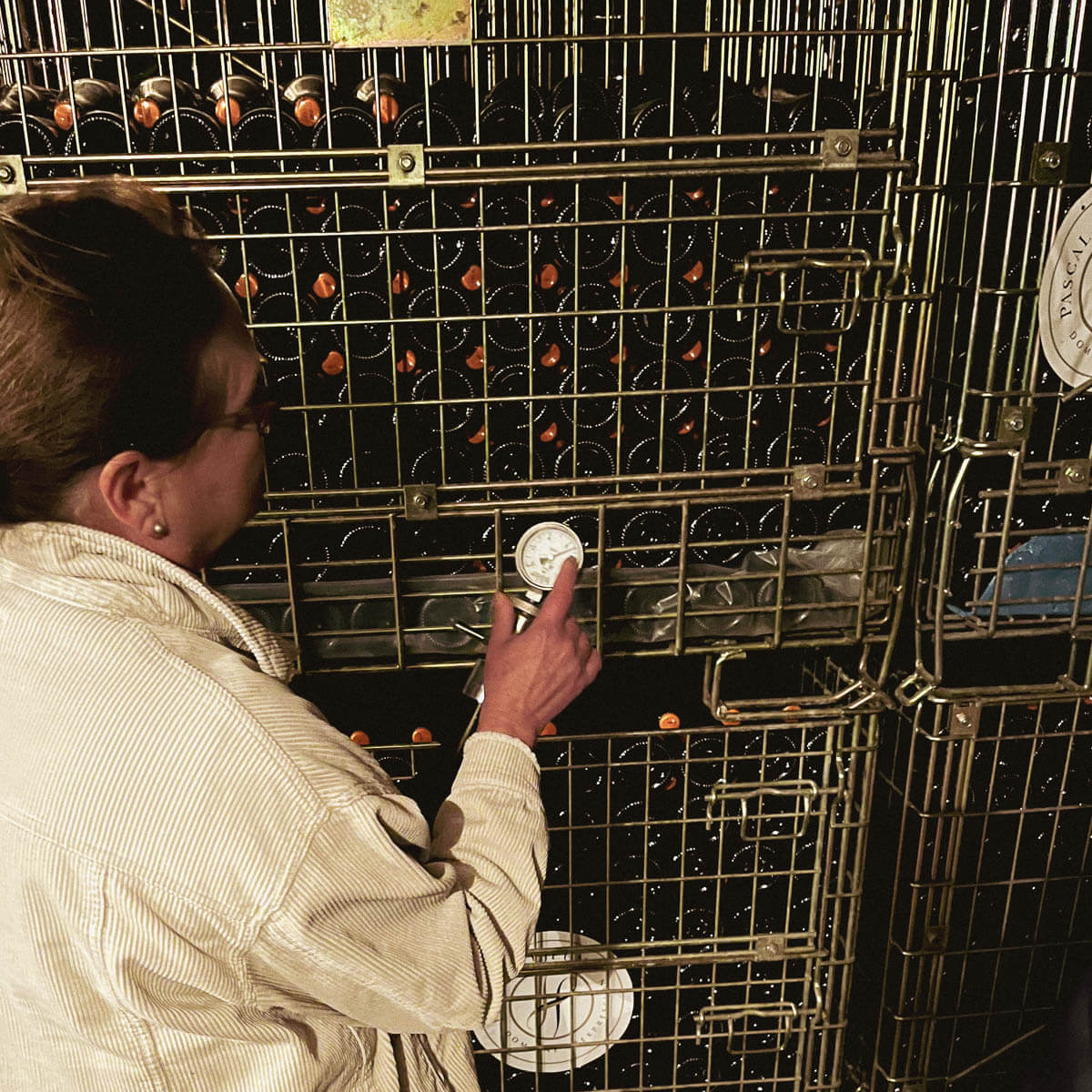 Sandrine Lejeune checking bottle pressure in the cellar — Champagne Pascal Lejeune, Moussy